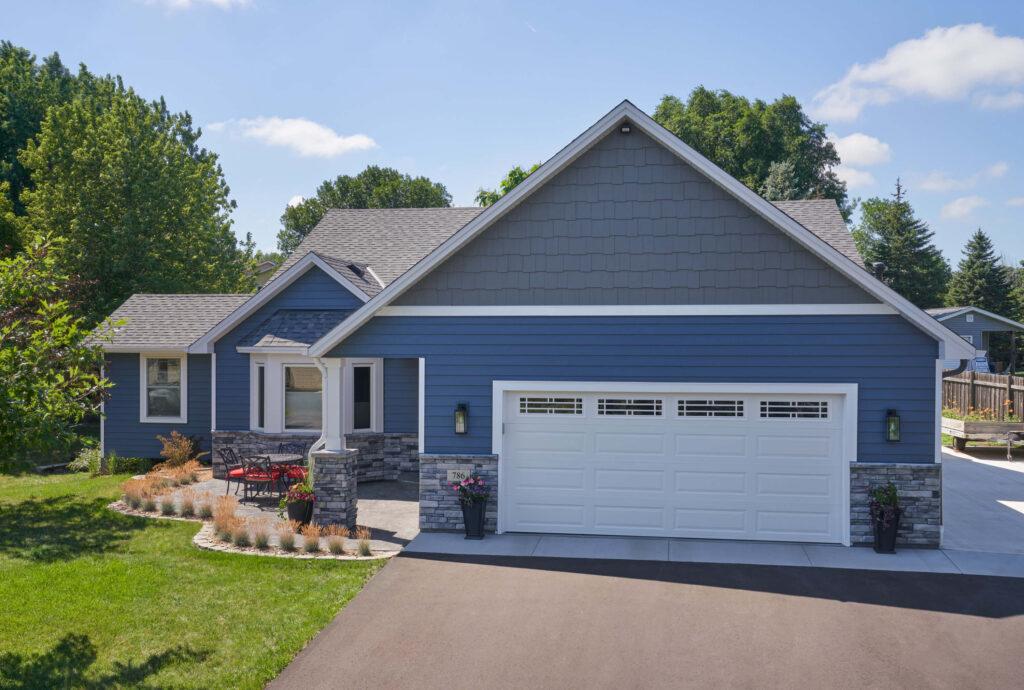 front view of a blue house with vinyl siding and shake siding