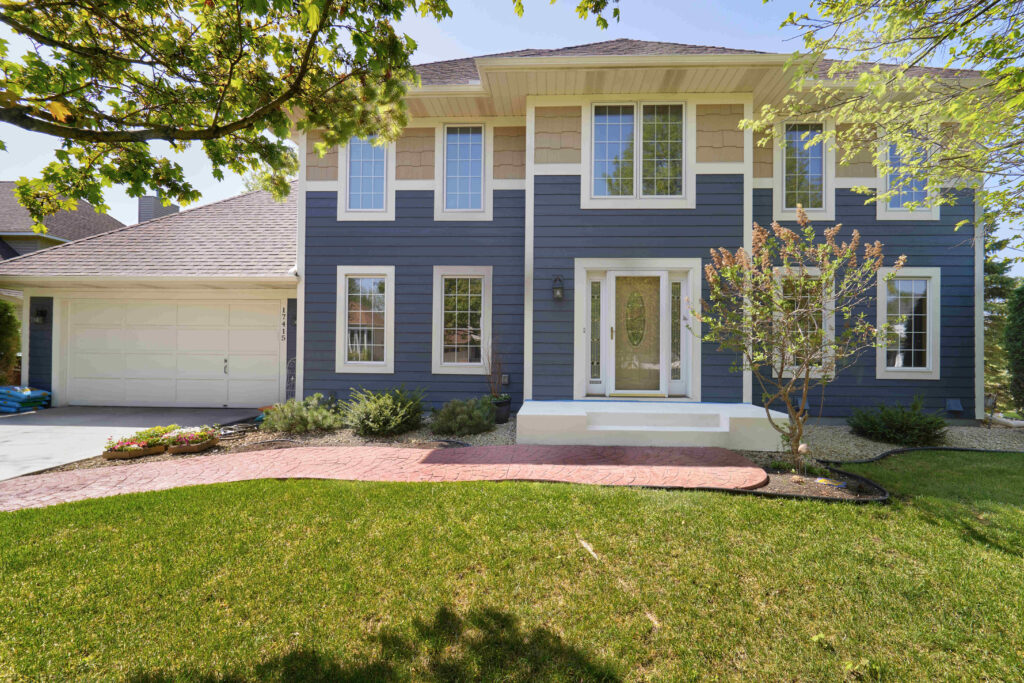 front house with blue siding halfway down and then beige siding toward the top